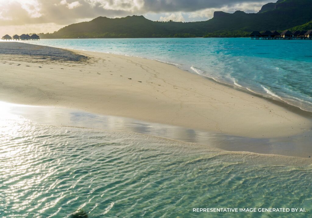Shallow turquoise water surrounding a narrow sandbar in Bora Bora.