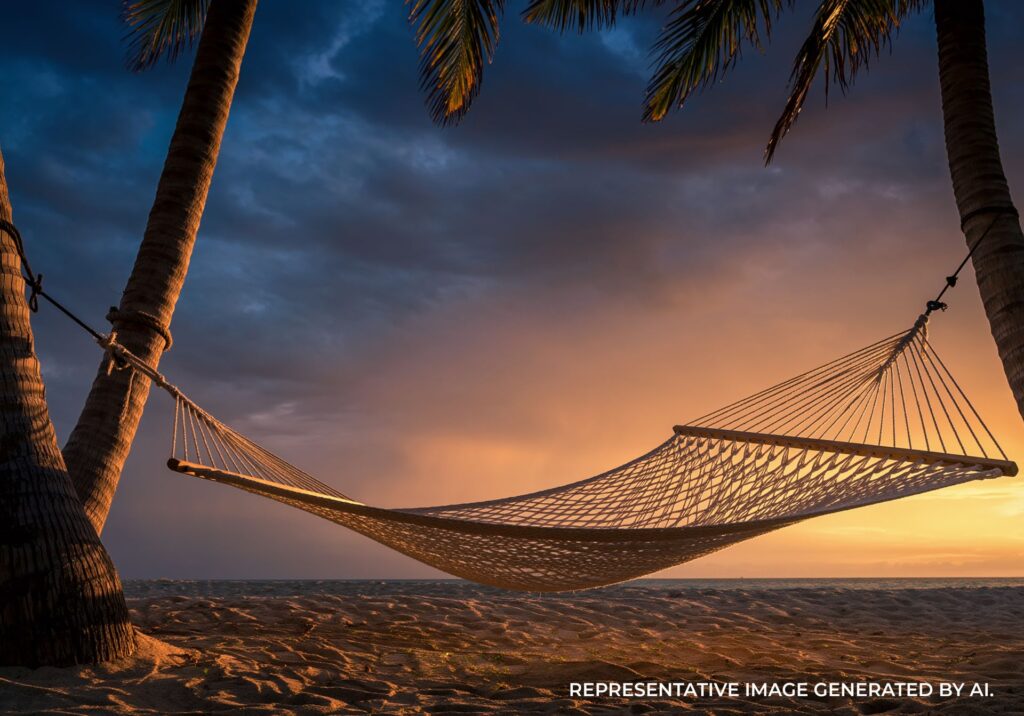 Hammock over calm water at sunset with palm trees in Jamaica
