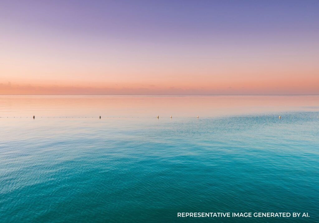 Calm ocean with pink sunset horizon and gentle waves in Jamaica