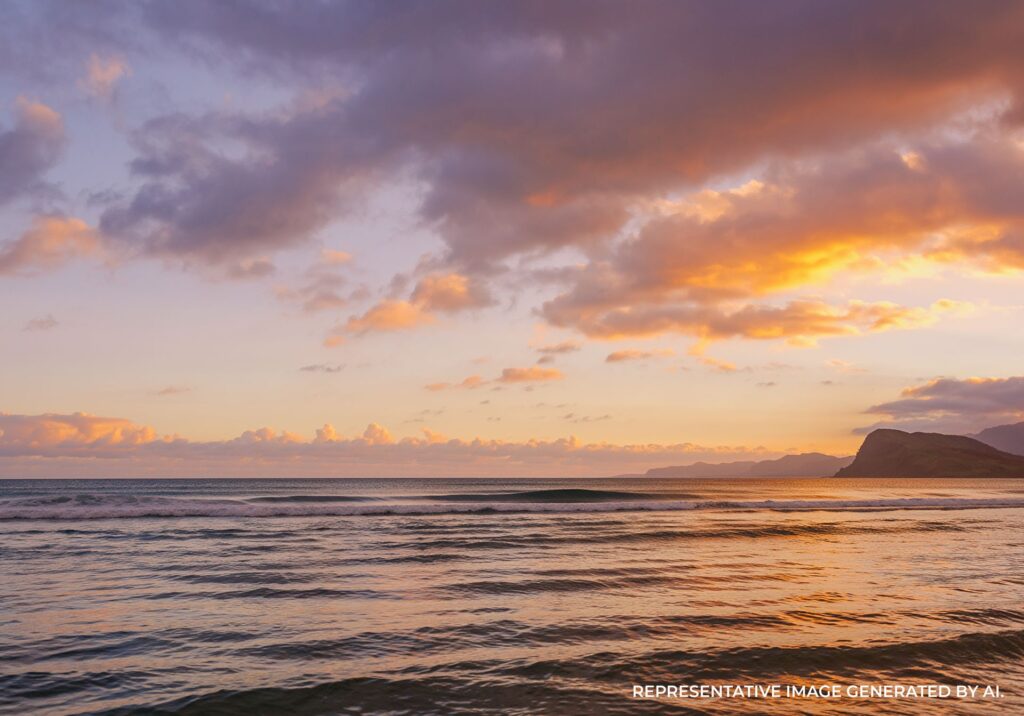 Vibrant purple and orange sunset across ocean surf.