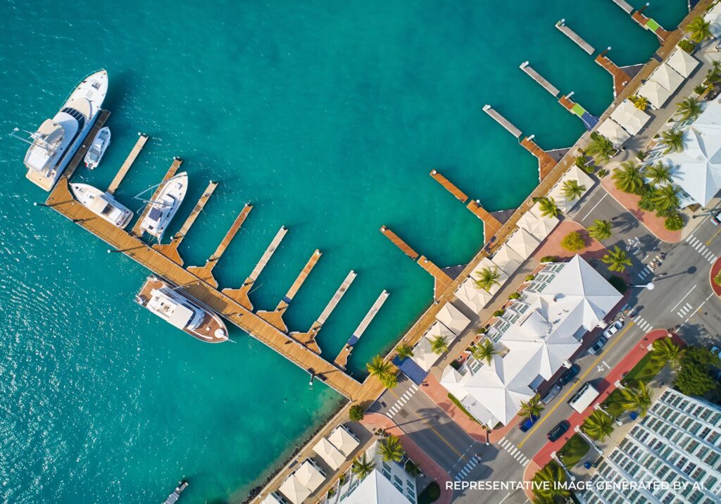 Overhead view of a Key West marina with turquoise water, wooden docks, and yachts along a waterfront street.