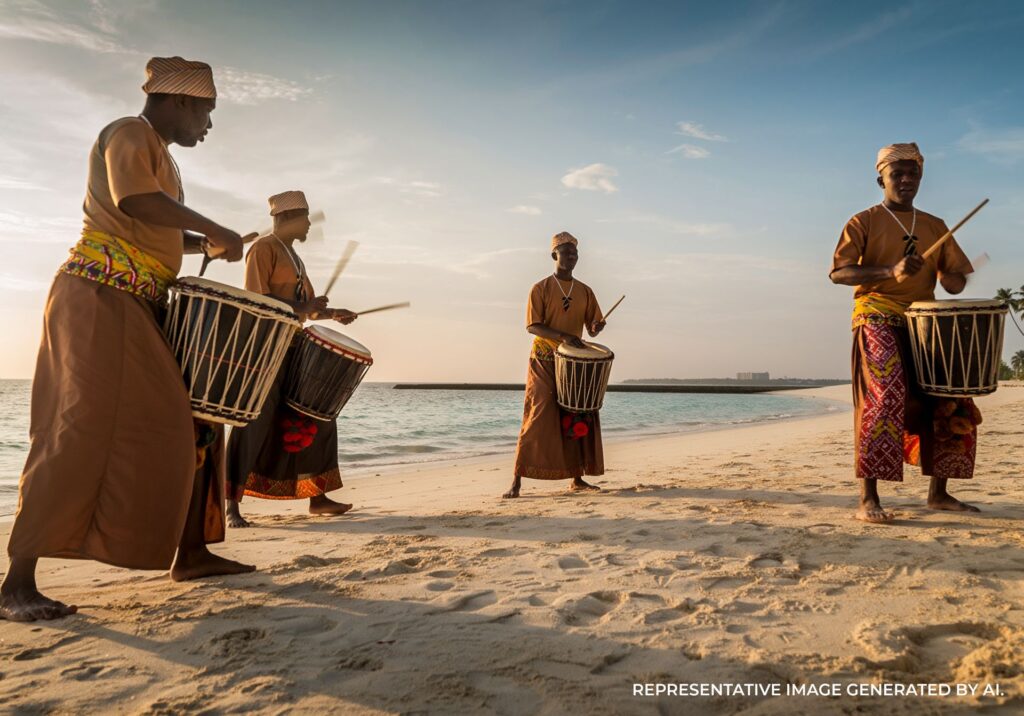 Cultural drumming performance on a Maldives beach at sunset with ocean backdrop
