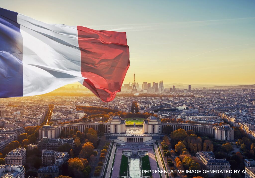 A French flag waving above the Paris skyline during sunset with warm golden light