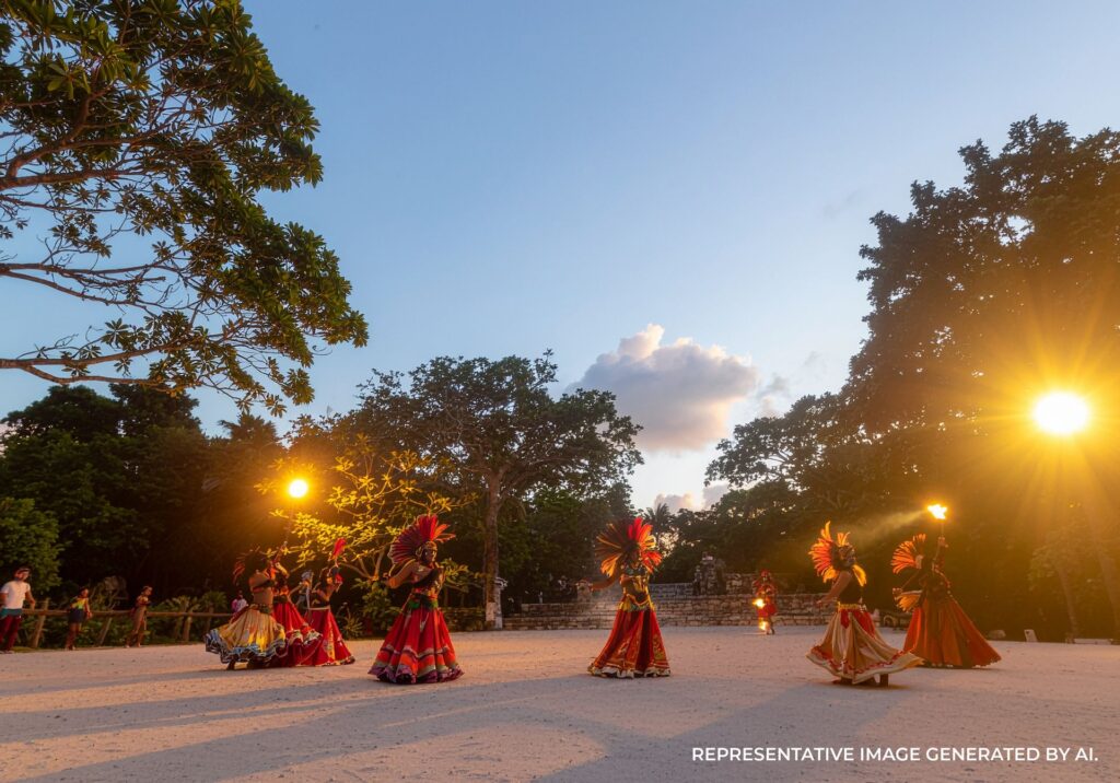 Traditional dancers performing in colorful attire at an outdoor cultural show near ancient ruins at sunset.