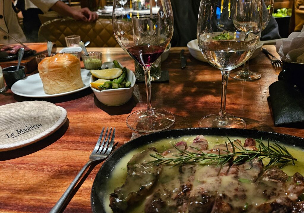 A plated steak in rich sauce served with wine glasses and fresh sides at an upscale Puerto Vallarta restaurant in Mexico