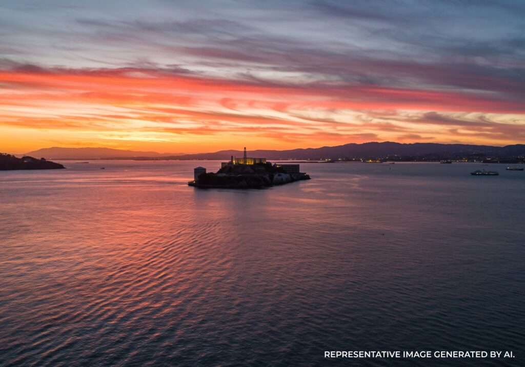 Vibrant sunset sky above Alcatraz Island with glowing water.