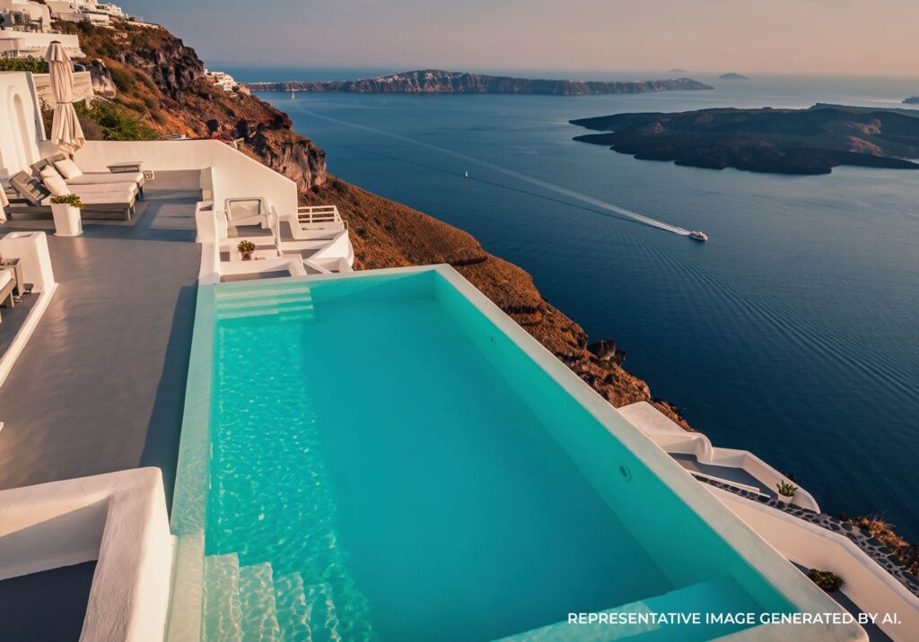 Luxury infinity pool overlooking the Santorini caldera and Aegean Sea at sunset.