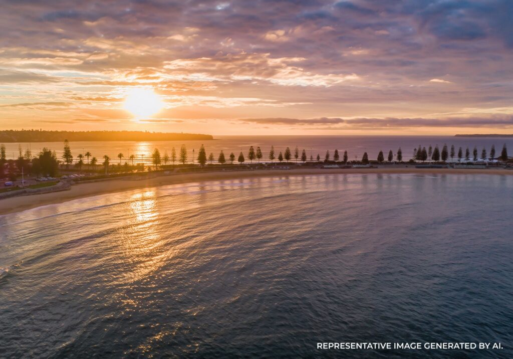 Soft morning light over a calm Sydney shoreline with gentle waves.