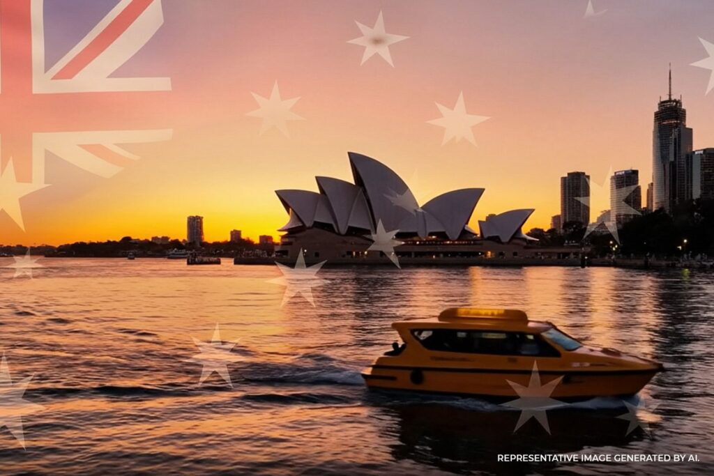 Sunrise over Sydney Harbour featuring the Opera House, Harbour Bridge, and a passing ferry on calm golden water.