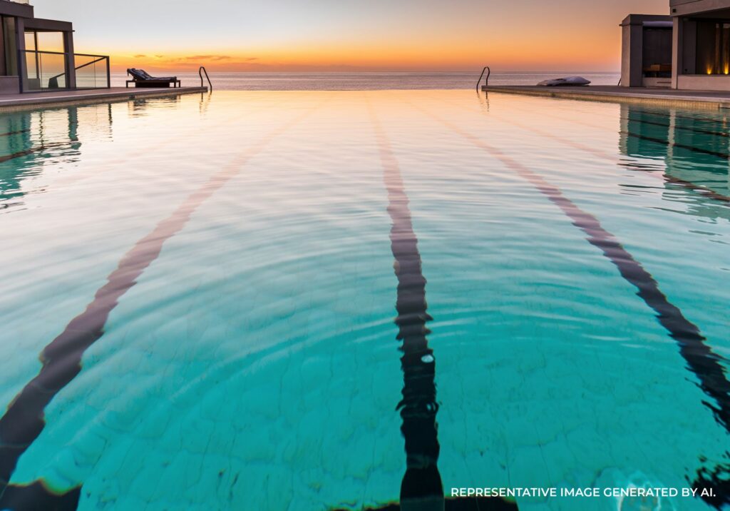 Sunrise over a Sydney ocean pool with calm waves and golden light reflecting across the water.