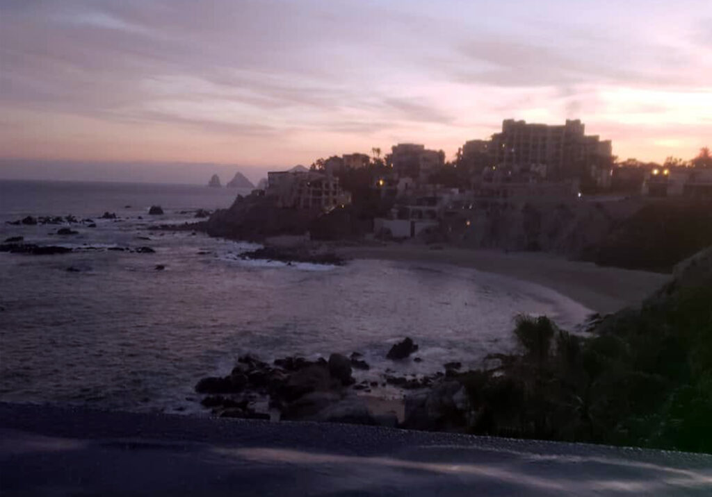 Rocky beach at sunset in Cabo San Lucas with gentle waves rolling in