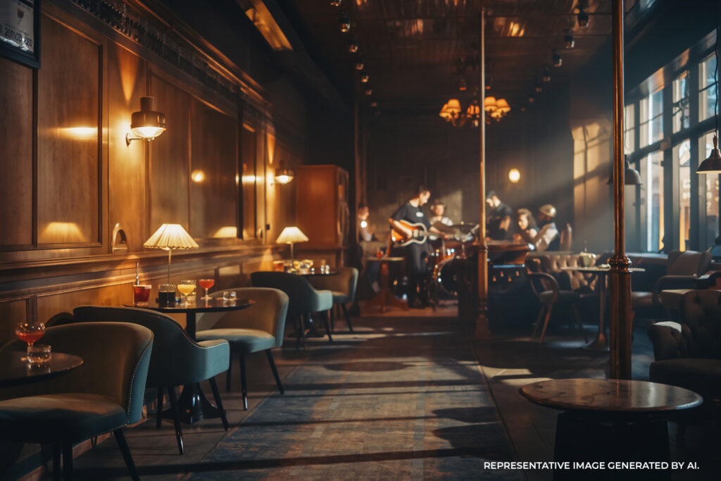 A dimly lit restaurant interior with chandeliers, tables, and warm ambient lighting.