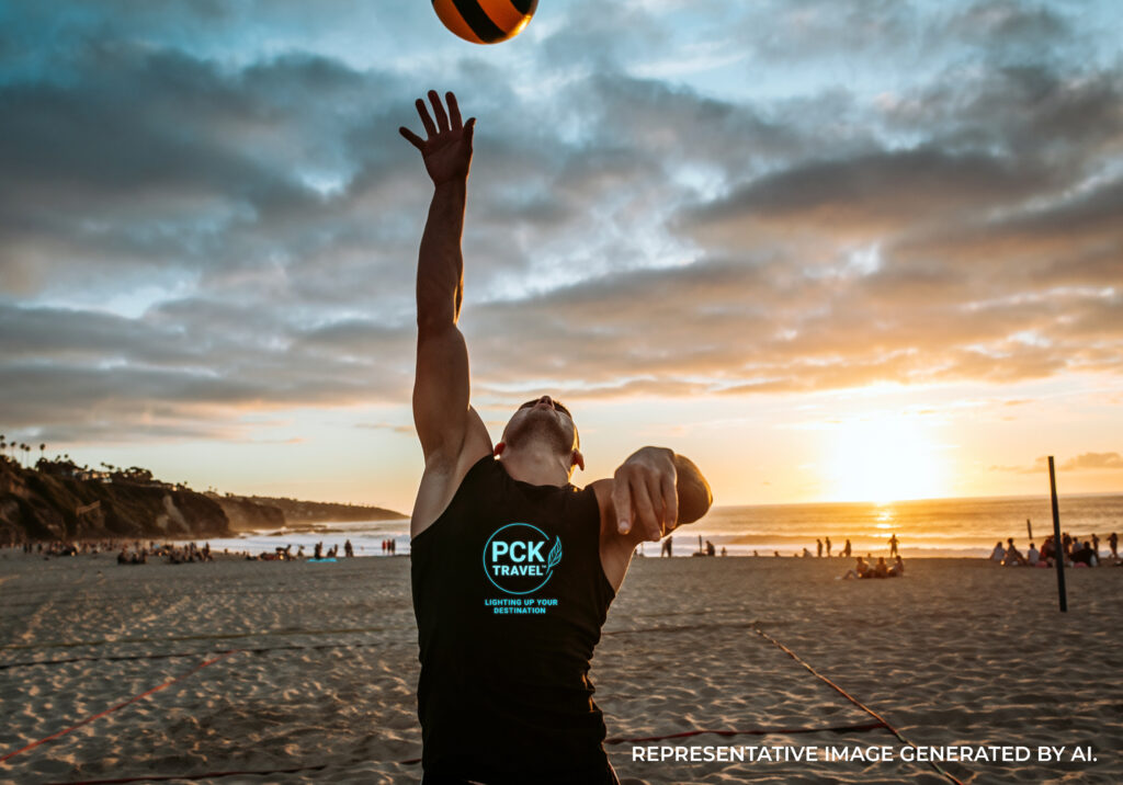 Male volleyball player jumping to hit a ball on the beach at sunset, San Diego LGBTQ activity