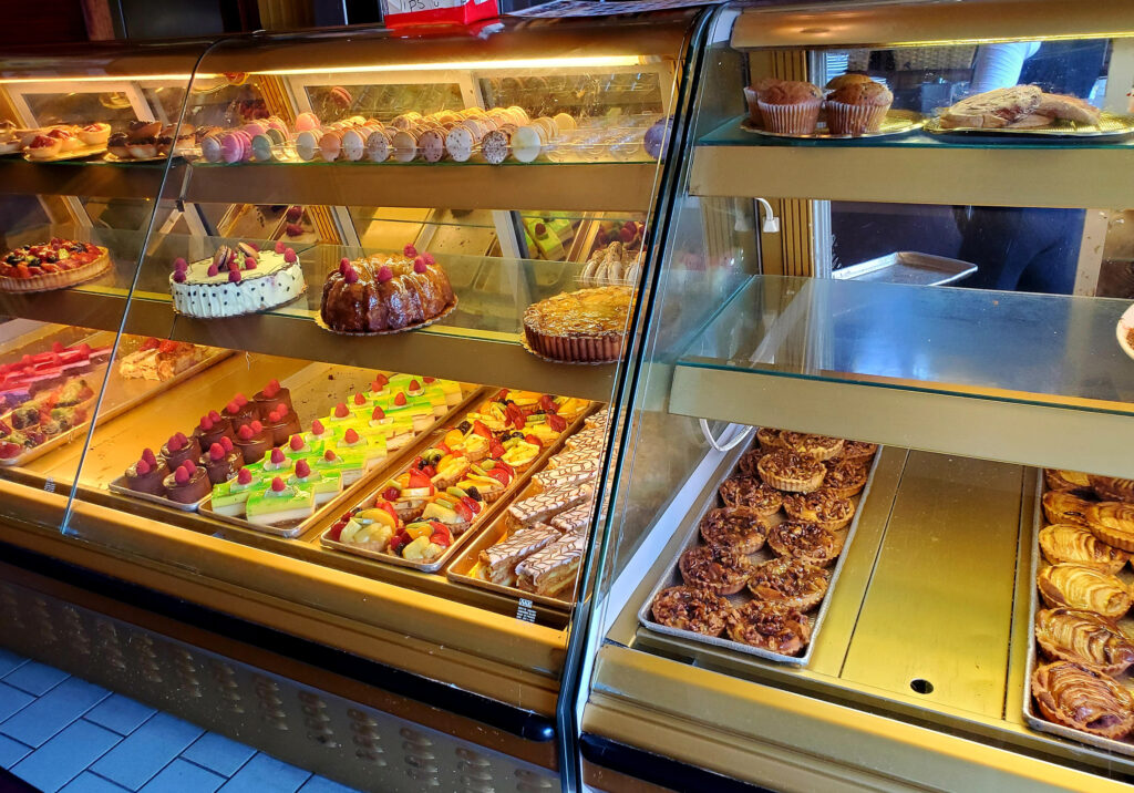 A deli case showcasing cakes and pastries from C’est La Vie in Laguna Beach, California
