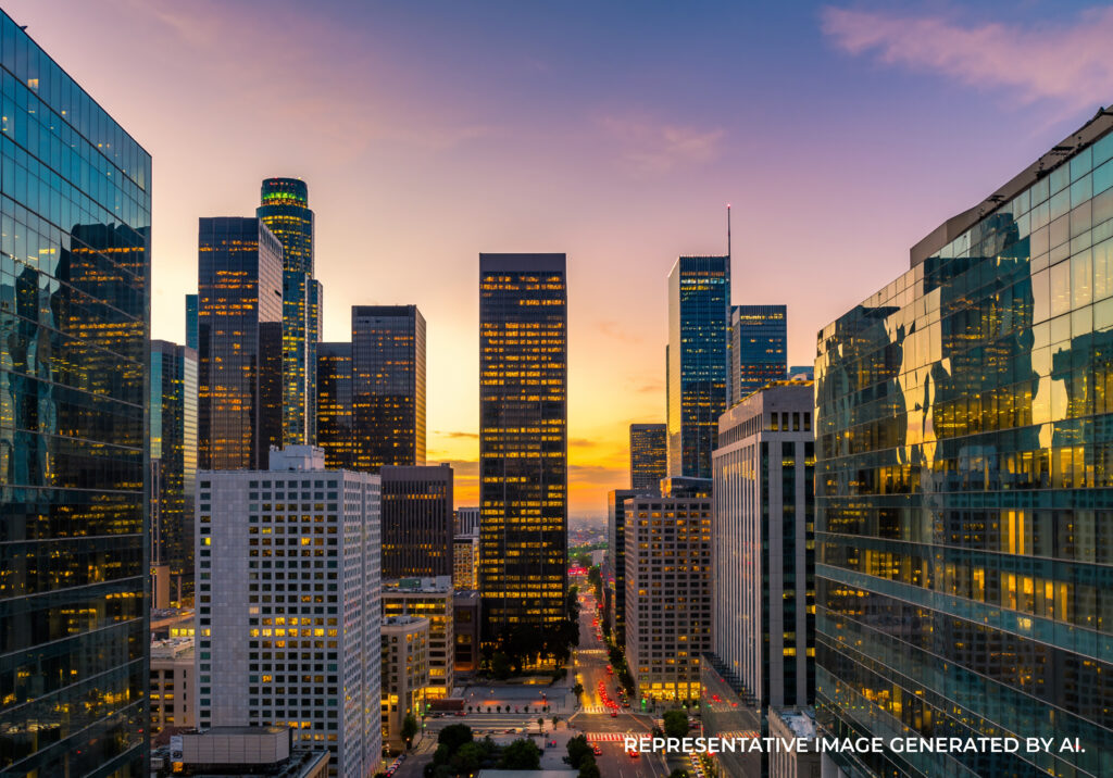Downtown Los Angeles skyscrapers lit by golden hour sunlight with reflective glass facades.