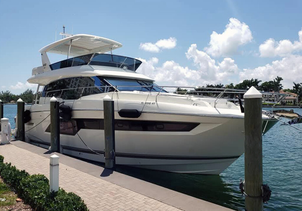 An image of a luxury yacht docked adjacent to a walkway.
