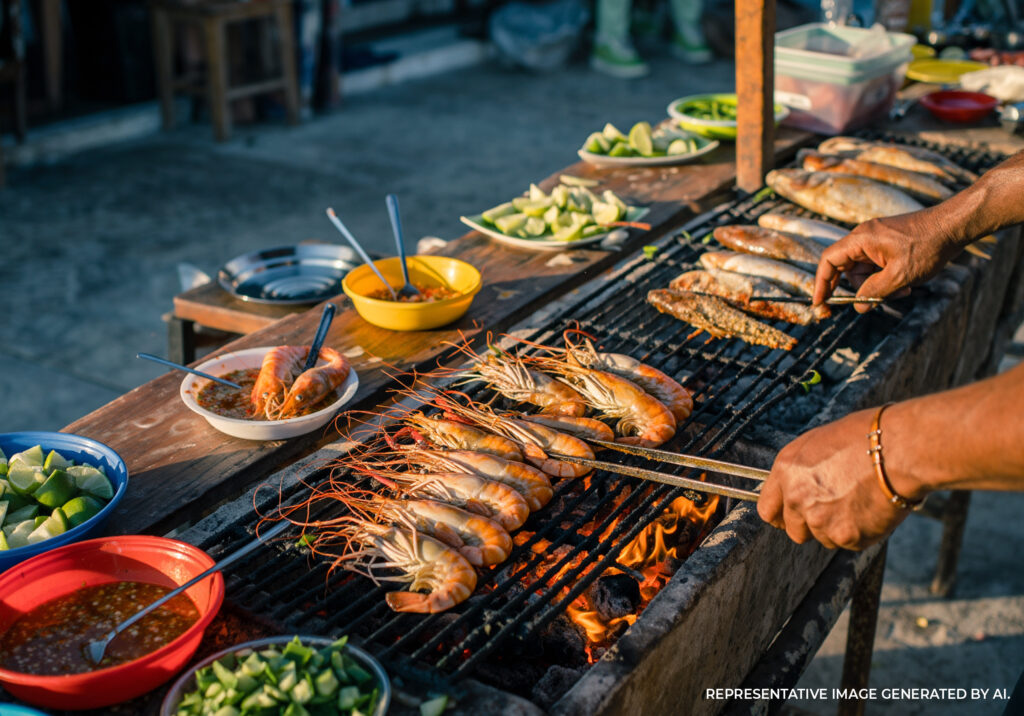 Grilled seafood and skewers cooking over open flame at a street food market in Tulum Mexico