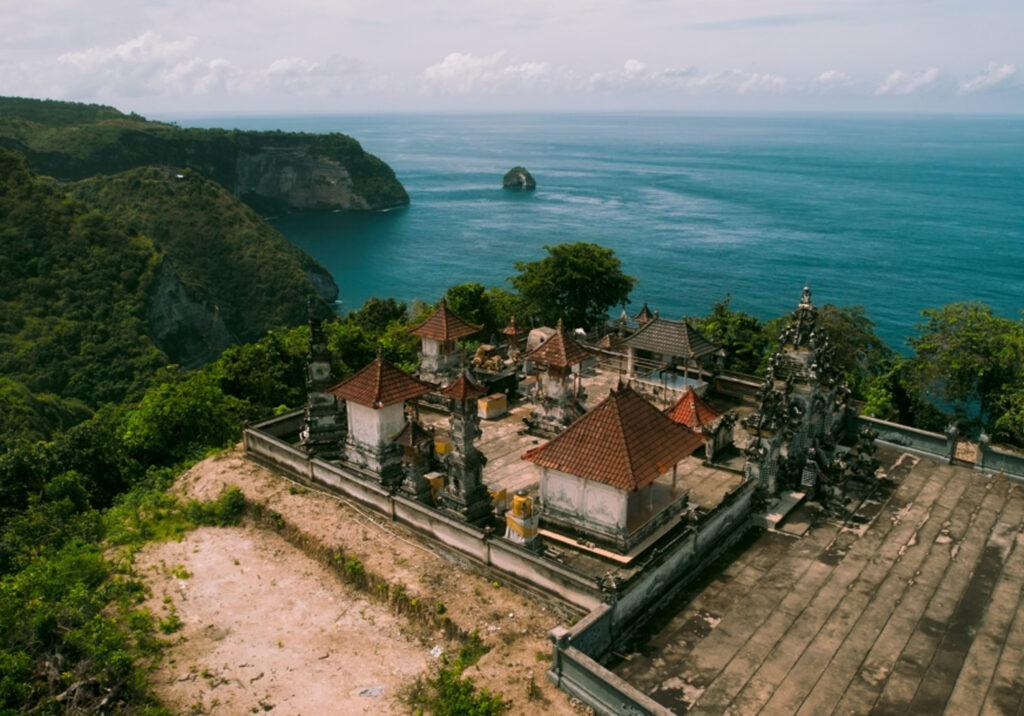 Coastal village with historic buildings overlooking the sea, photographed from an elevated perspective.