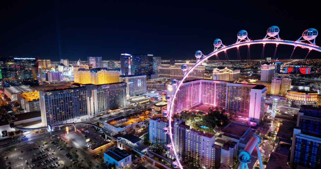 Las Vegas Strip at night with High Roller observation wheel and illuminated hotels