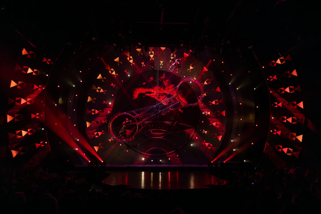 ʻAuana by Cirque du Soleil® fire and volcano scene with aerial performers in a dramatic red stage setting