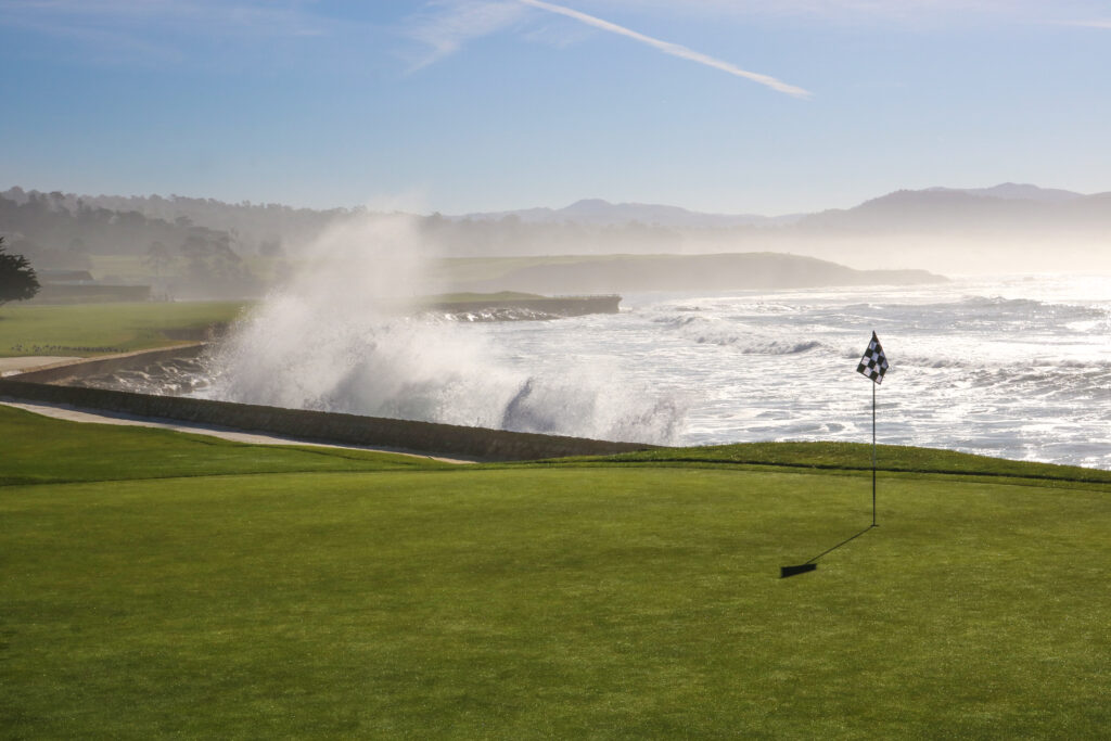 Powerful waves crashing beside Pebble Beach Golf Links fairway along the Pacific Ocean.