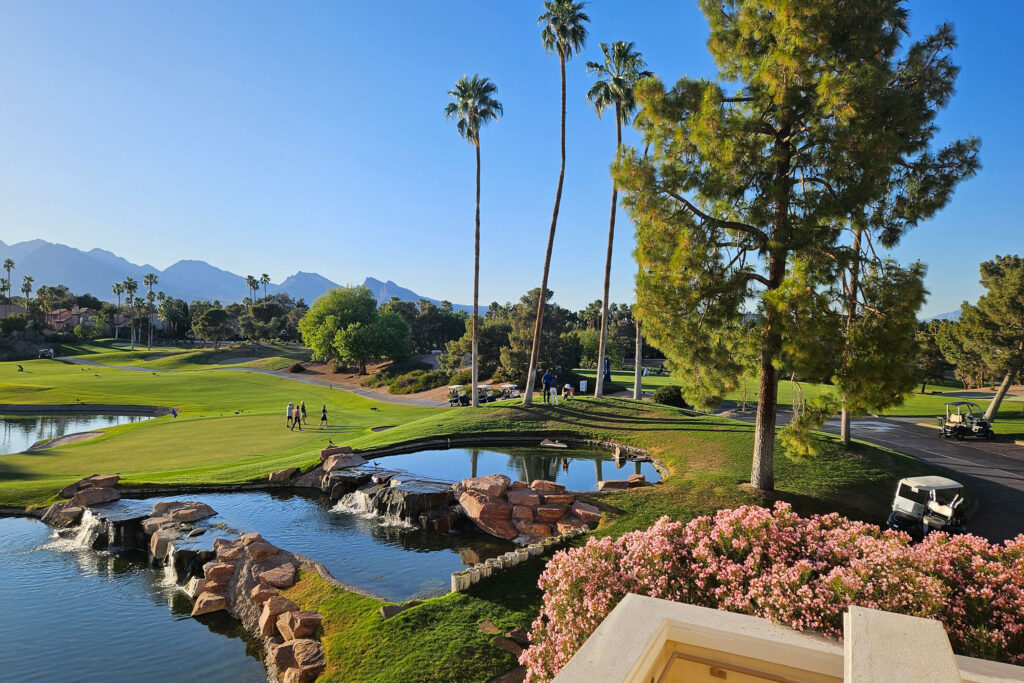 Golf course with water bridge, palm trees, and landscaped greens at Canyon Gate