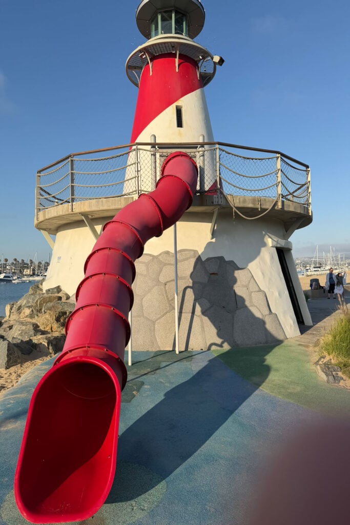 Red spiral slide at the Newport Beach lighthouse overlooking the marina