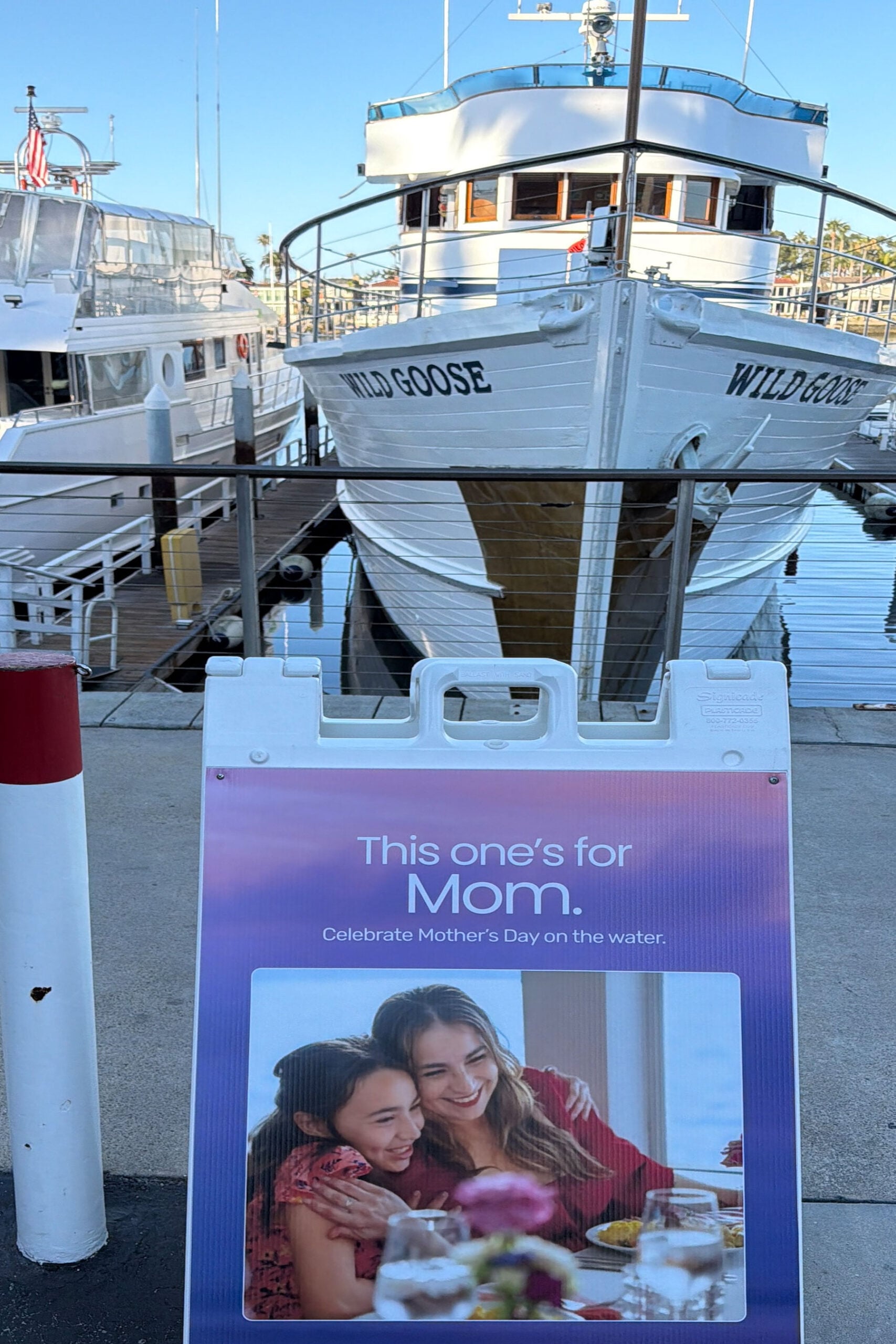 View of marina dock area in Newport Harbor with signage and boats