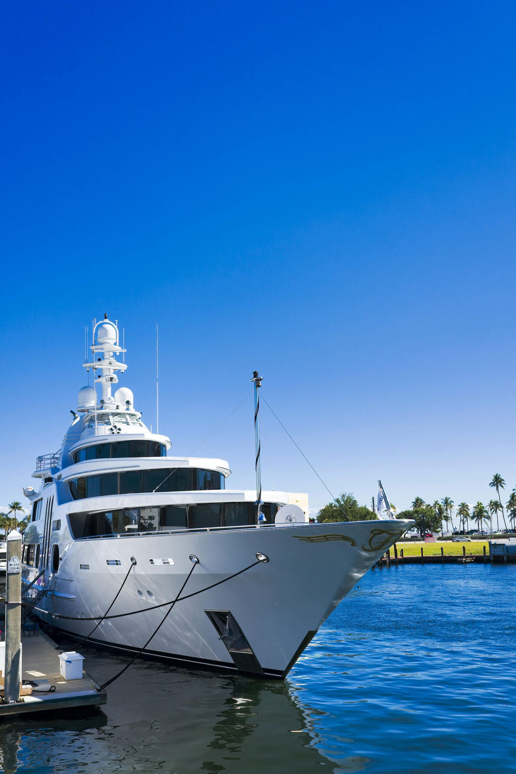 Luxury yacht docked at marina under blue sky