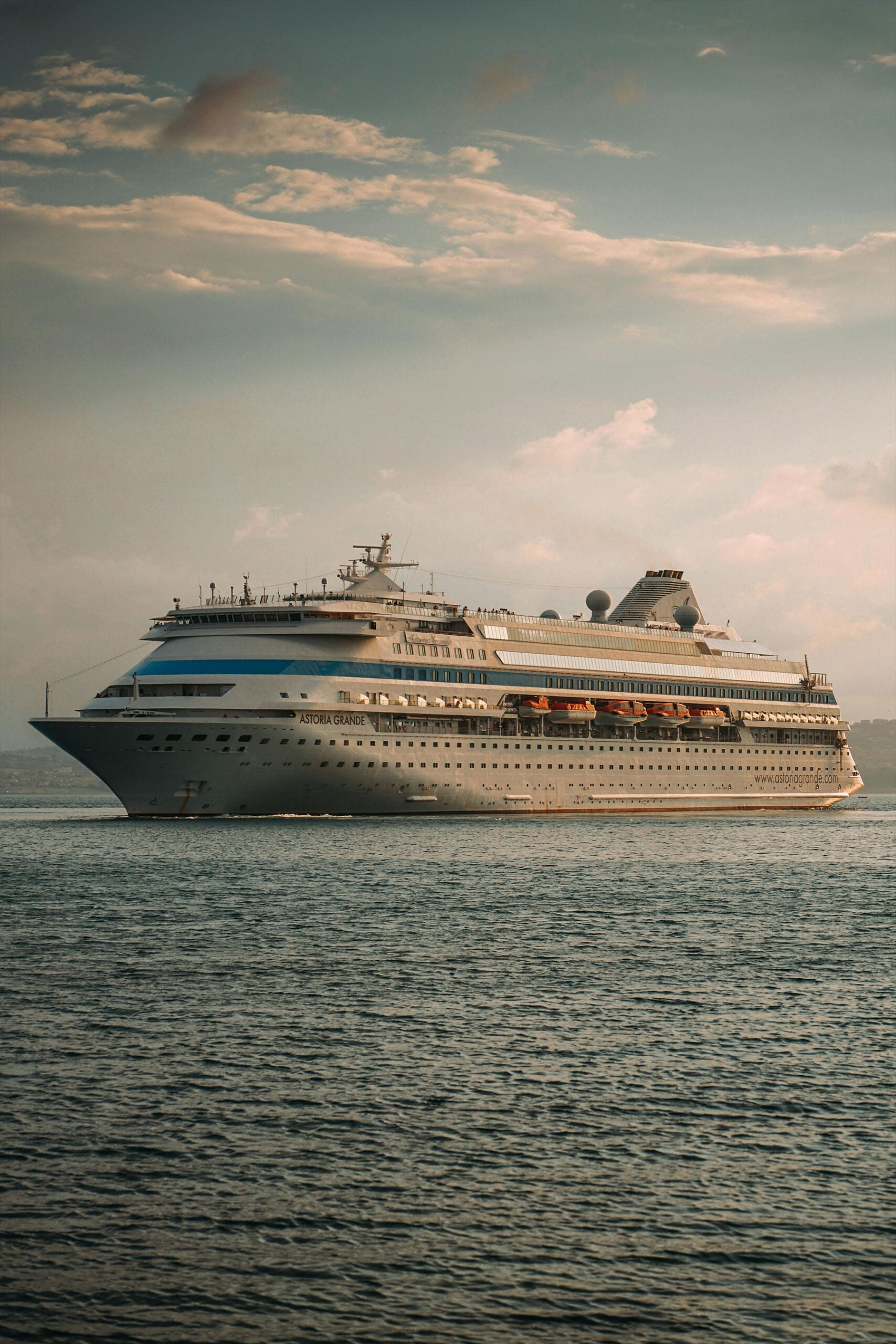 Luxury cruise ship sailing at sunset on open water