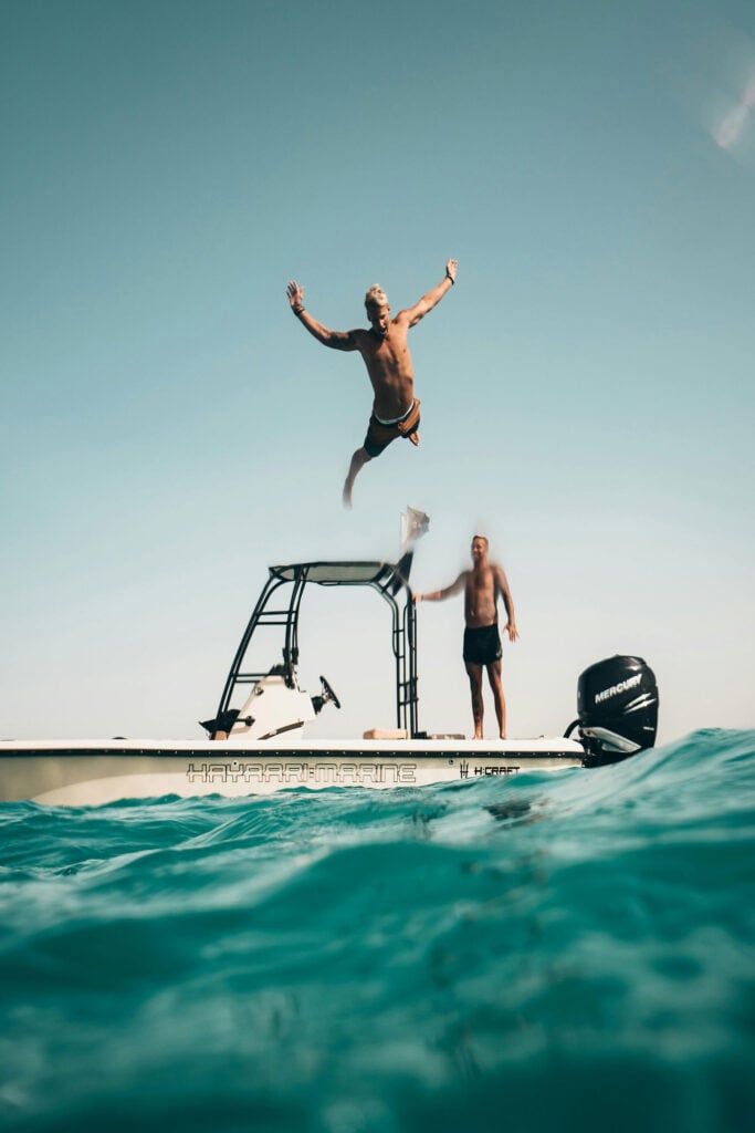 Travelers jumping into the ocean from a boat during a coastal adventure