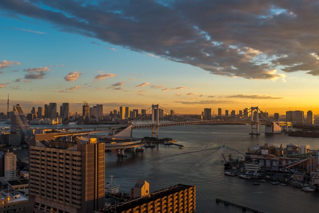 Sunset view overlooking Tokyo Bay with modern buildings, waterways, and the city skyline.