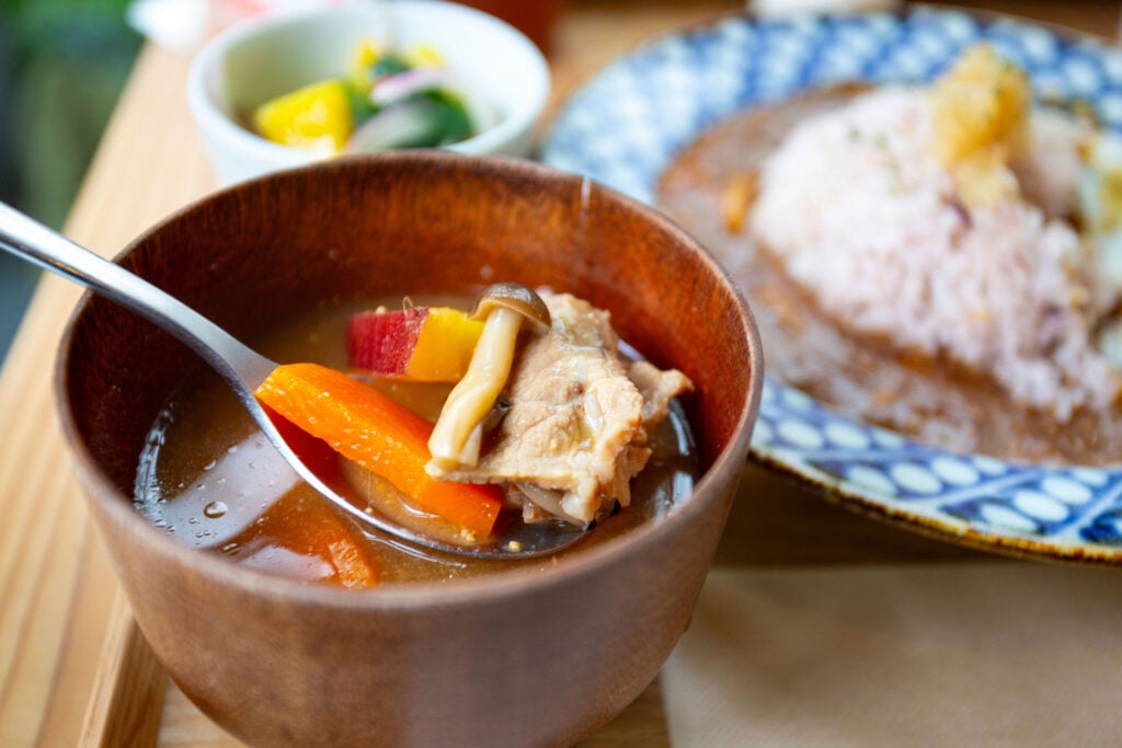 Traditional Japanese meal featuring seasonal vegetables, seafood, and beautifully presented broth.