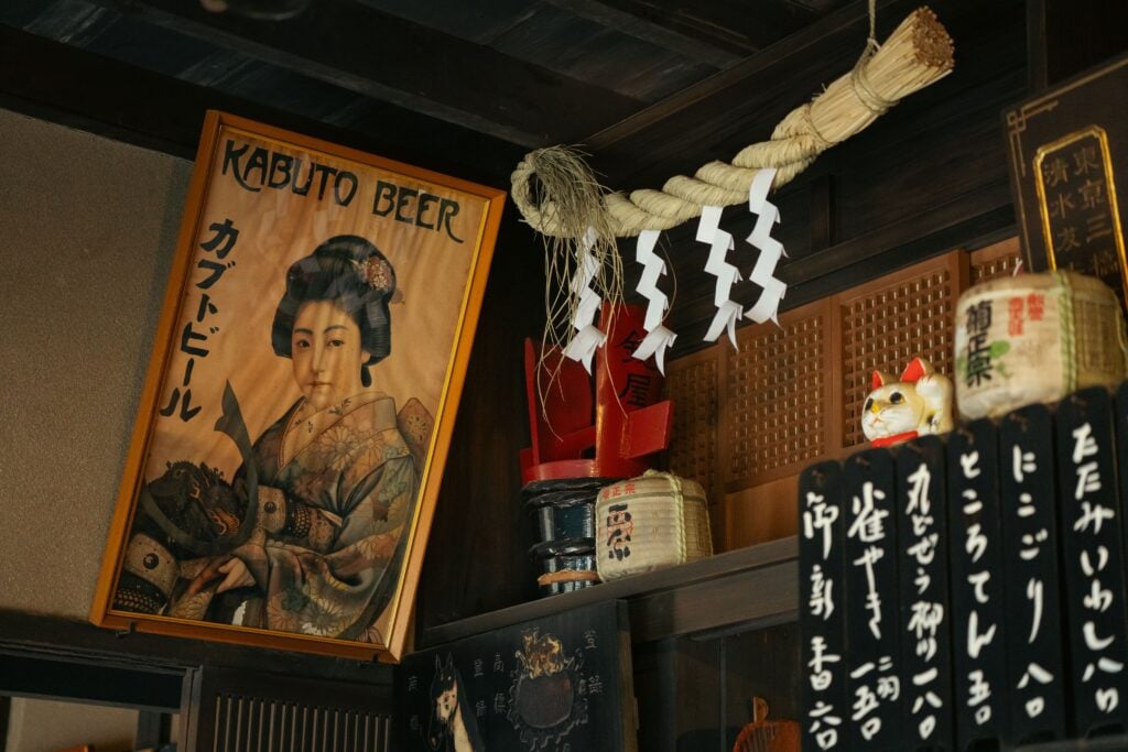 Entrance to a traditional Japanese izakaya decorated with lanterns, signage, and vintage artwork in Tokyo.