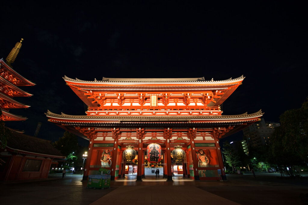 Historic Hōzōmon Gate illuminated at night within the Sensō-ji Temple complex in Tokyo.