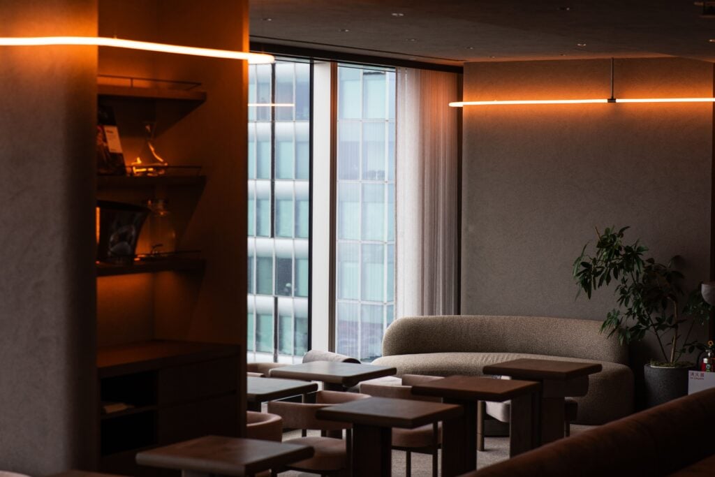 Elegant hotel lounge with floor-to-ceiling windows overlooking the Tokyo skyline.